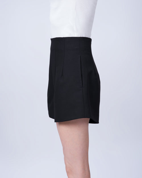 Women’s high-waisted black tailored shorts in a breathable Tencel blend. Side view highlighting the tailored fit, clean lines and comfortable silhouette. Made in Singapore and individually finished by hand.