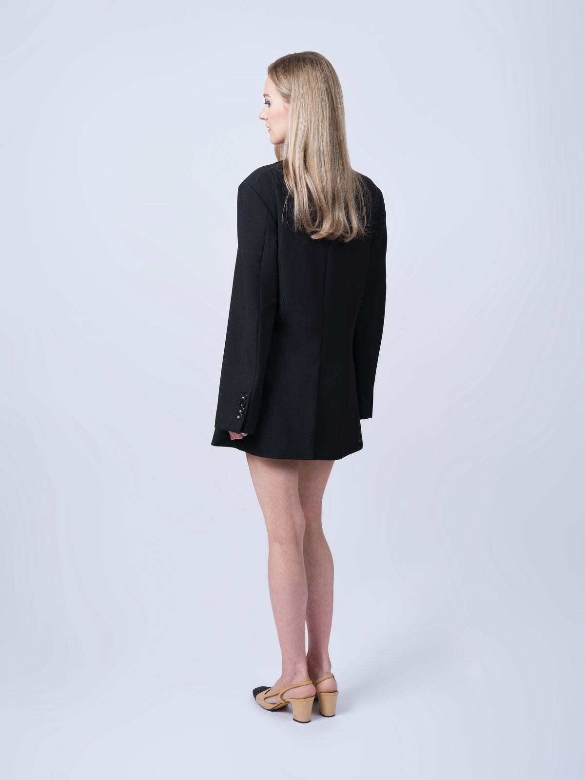 Women’s black tailored blazer without belt shown from an angled view. Featuring a relaxed oversized fit, structured tailoring and breathable Tencel-blend fabric. Made in Singapore and individually finished by hand.