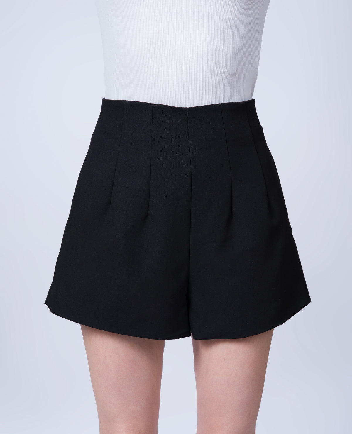 Women’s high-waisted black tailored shorts in a breathable Tencel blend. Front view showcasing the flattering silhouette, tailored construction and contemporary design. Made in Singapore and individually finished by hand.