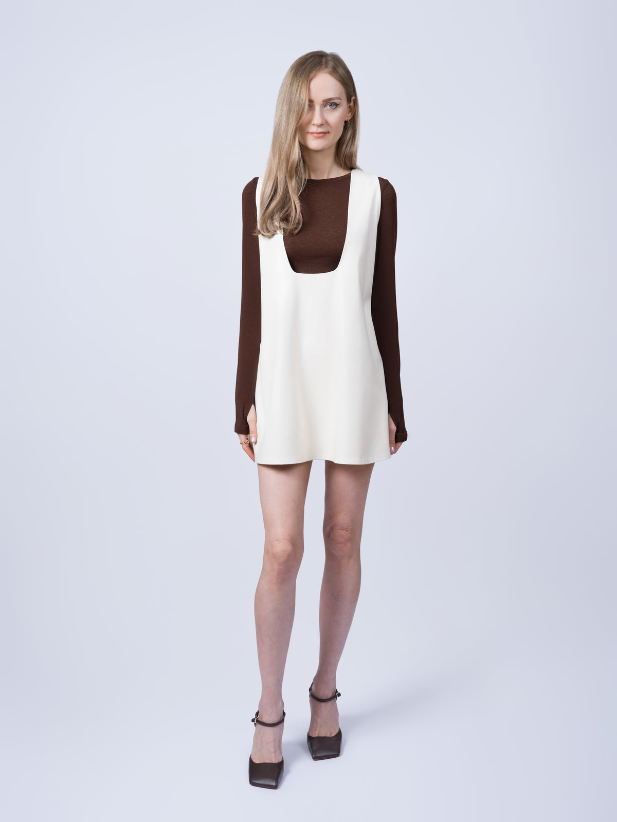 Women’s ecru vegan leather pinafore dress in an oversized silhouette. Full-length front view highlighting the sleeveless design, relaxed fit and versatile styling.